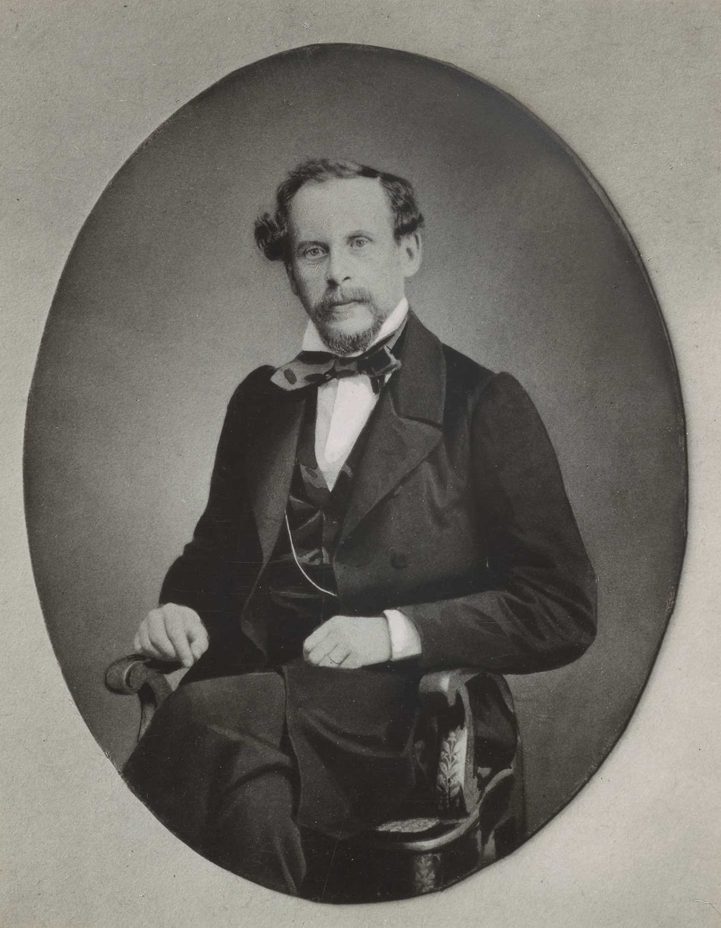 Portrett av en sittende Christian Munch kledd i mørk dress og vest. Fotografi.