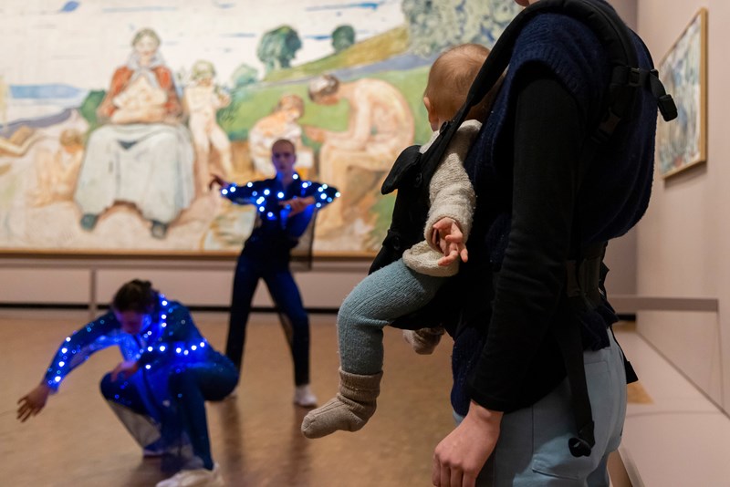 Baby and mother looking at two dancers