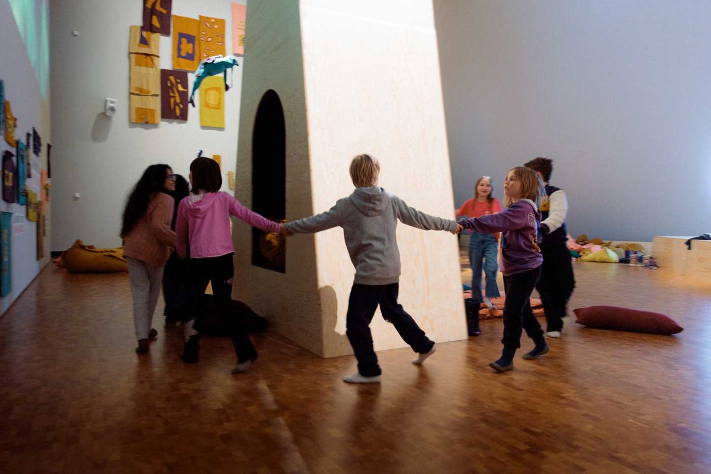 Barn leker i Kaoskammeret, de holder hverandre i hendene og løper i ring rundt en høy portal