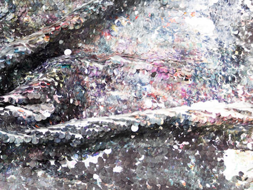 Close up of hand painted sequins silver shimmering colour play.