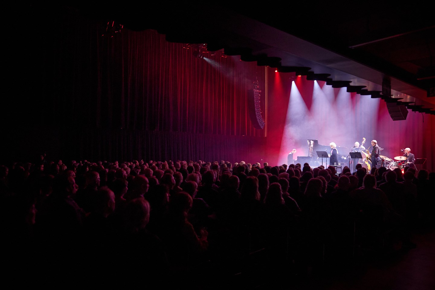 Jazz musicians on stage in a full concert hall